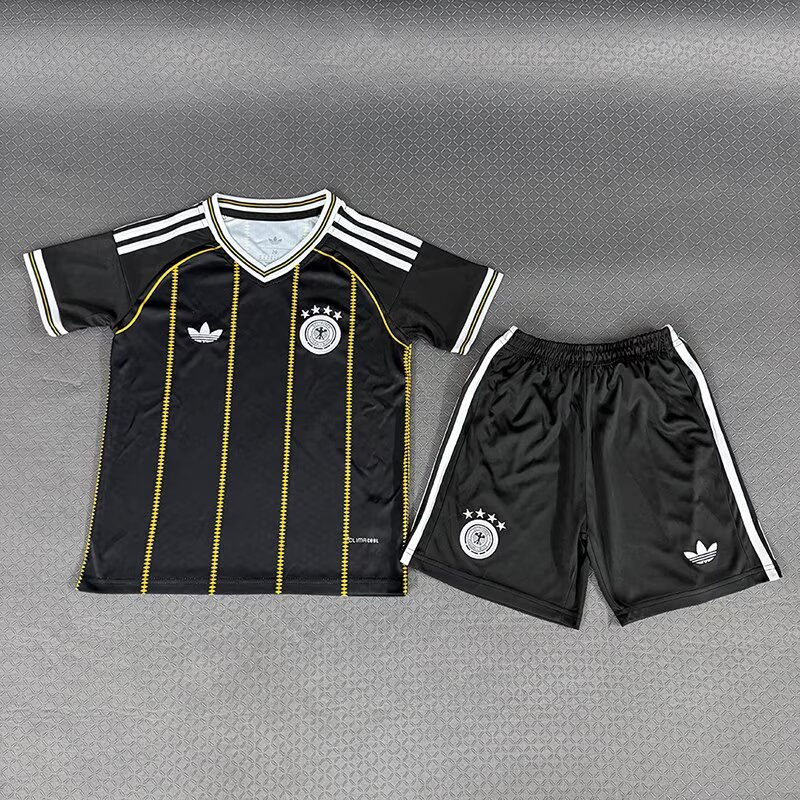 Germany children’s black shirt with gold-coloured vertical detailing beside black shorts, front view
