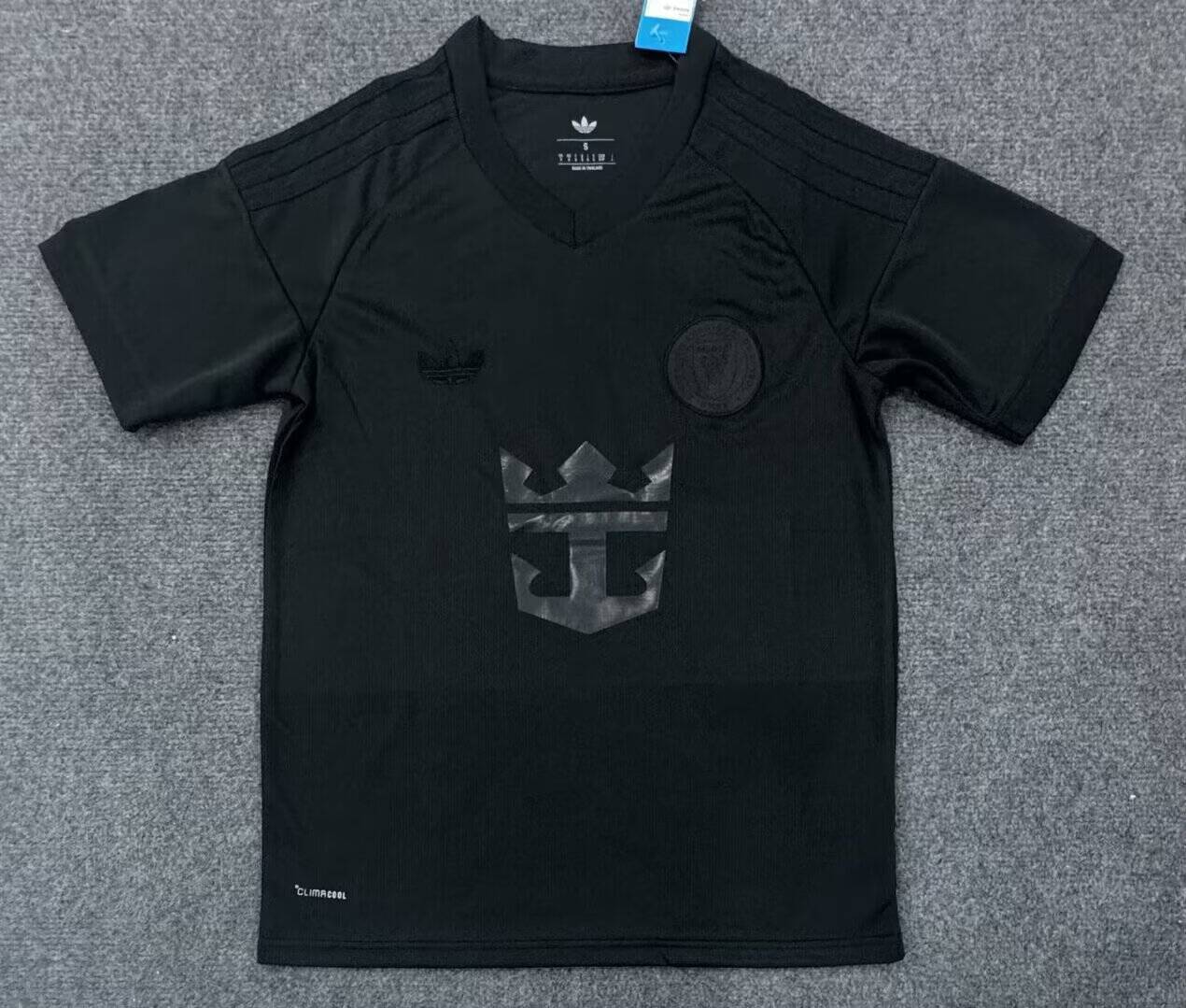 Front: tonal chest emblems and a glossy crown-and-anchor graphic on a black base.