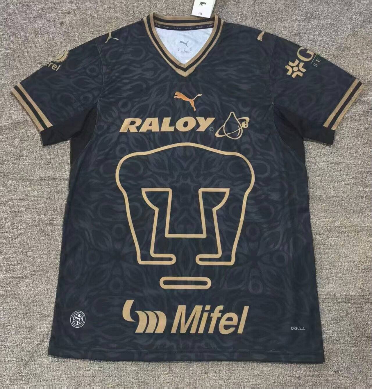 Front: oversized outlined Pumas emblem, RALOY and Mifel prints, gold trim and a dark tonal pattern.